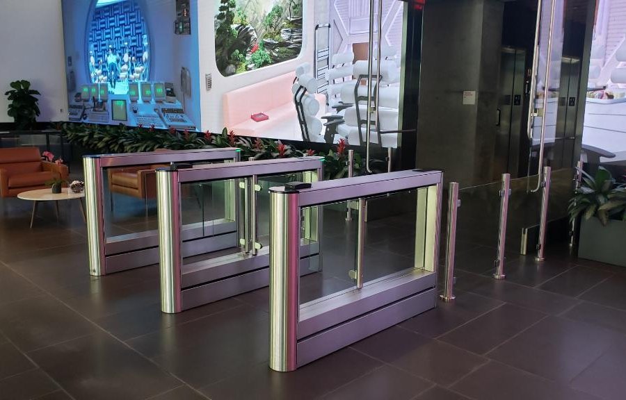 Employees passing easily through Fastlane optical turnstiles from Smarter Security in a corporate lobby